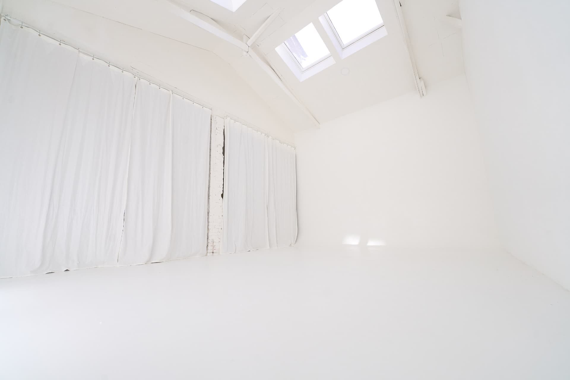Cyclorama blanc avec rideaux diffusants et lumière naturelle